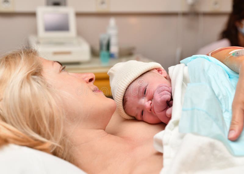 Mamã e pele recém-nascida do bebê à pele após o nascimento no hospital
