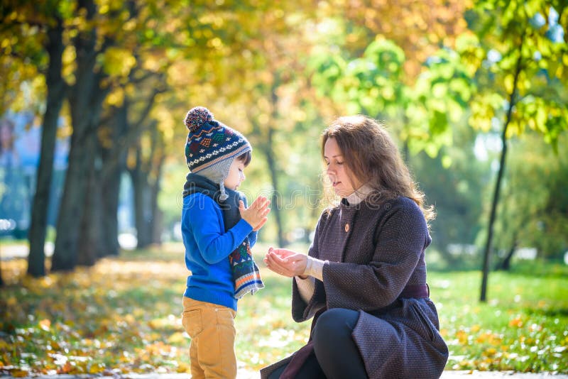 Mamãe e bebê brincam no parque de outono Pais e crianças caminham na floresta num dia ensolarado de outono Crianças brincando ao