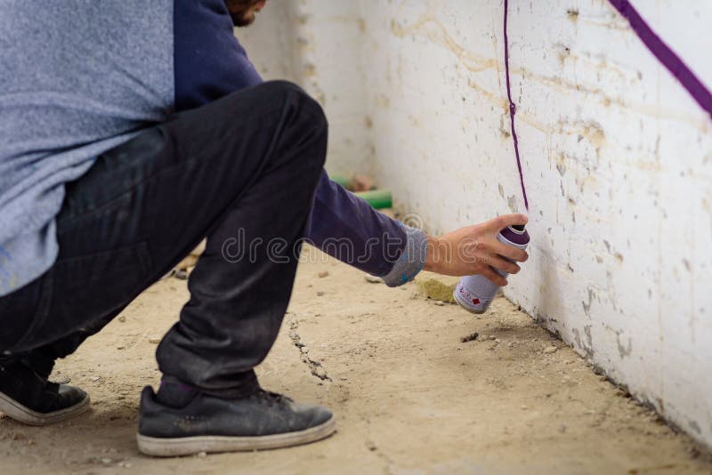 Man with aerosol paint to paint a graffiti royalty free stock images
