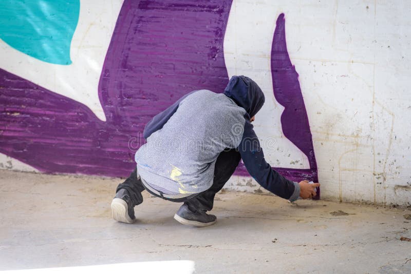 Man with aerosol paint to paint a graffiti stock images