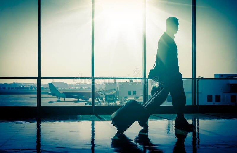 L'uomo walikng all'Aeroporto con la Valigia.