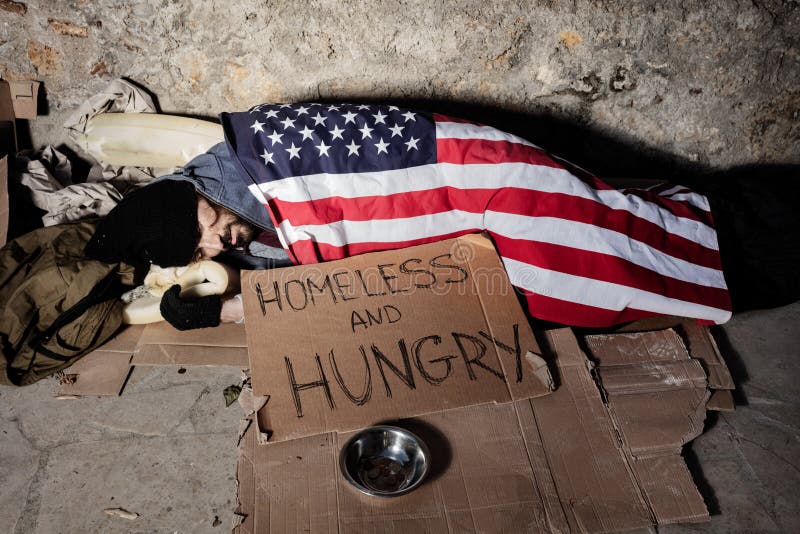 Man with alms bowl sleeping under American flag