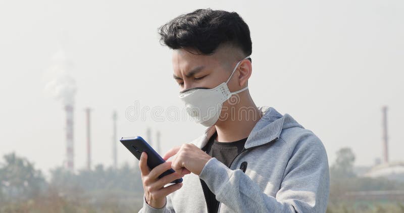 Man använder smartphone med mask royaltyfria bilder