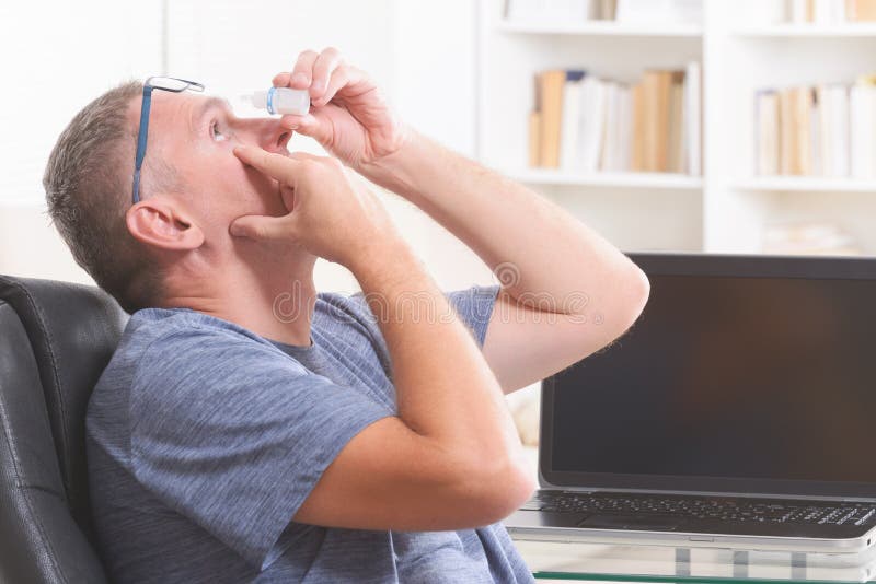 Man applying eye drops royalty free stock images