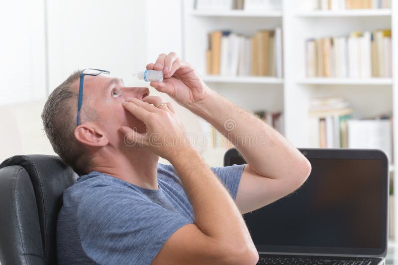 Man applying eye drops stock image Man applying eye drops stock image
