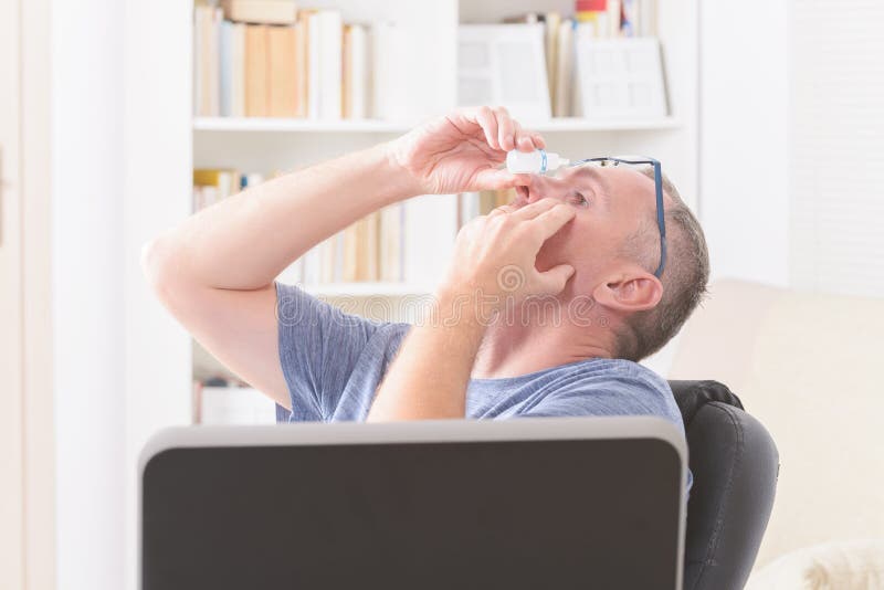 Man applying eye drops royalty free stock images