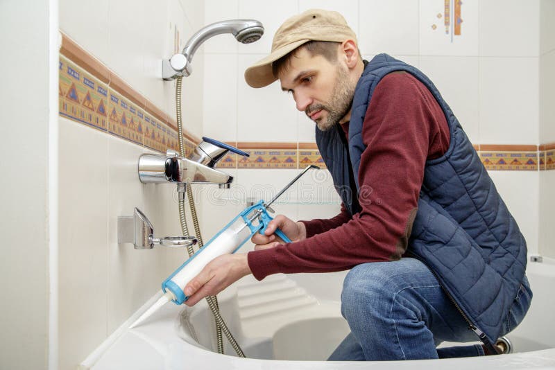 Man Applying Silicone Sealant in the Bathroom. Stock Photo - Image of ...