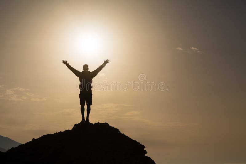 Man with arms outstretched celebrating or praying in beautiful inspiring sunrise with mountains and sea. Man hiking or climbing with hands up enjoy inspirational landscape on rocky top on Crete. Man with arms outstretched celebrating or praying in beautiful inspiring sunrise with mountains and sea. Man hiking or climbing with hands up enjoy inspirational landscape on rocky top on Crete.