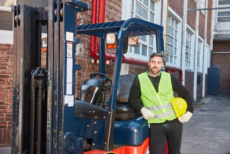 Forklift Driver with Forklift in Front of the Warehouse Stock Image