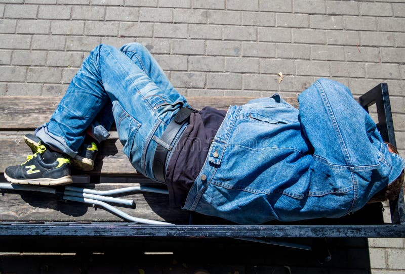Man asleep lying on a bench royalty free stock photos Man asleep lying on a bench royalty free stock photos