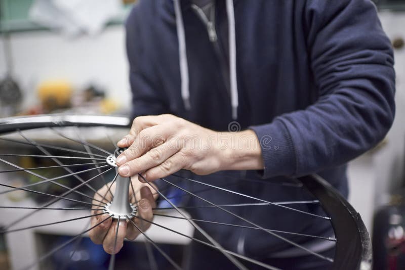 Man Assembling a Bike Wheel Axle after the Process of Cleaning and