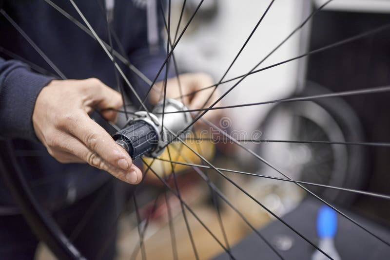Man Assembling a Bike Wheel Axle after the Process of Cleaning and