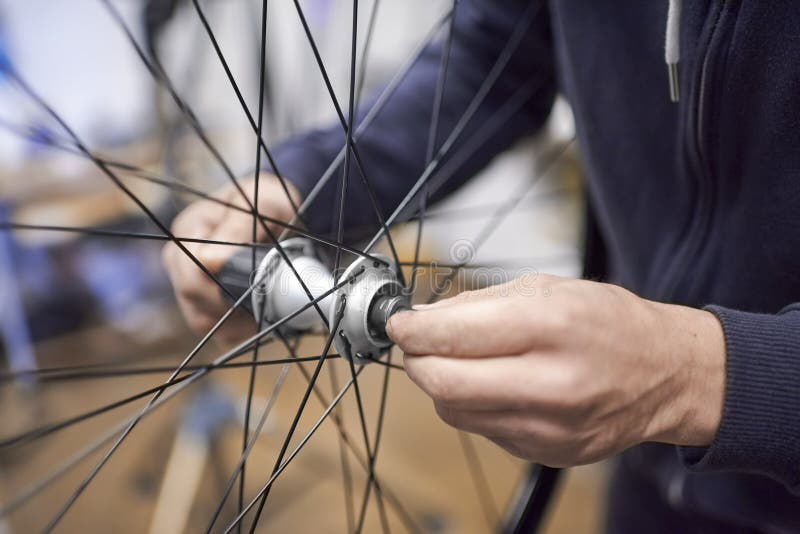 Man Assembling a Bike Wheel Axle after the Process of Cleaning and