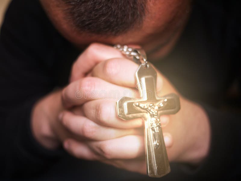 Man att be och att rymma ett kors med Jesus royaltyfria foton Man att be och att rymma ett kors med Jesus royaltyfria foton