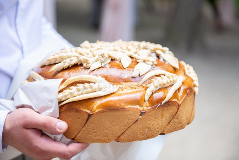 Man att gå och att rymma den traditionella ukrainska bröllopstårtan med spikelets läckert släntra arkivfoton Man att gå och att rymma den traditionella ukrainska bröllopstårtan med spikelets läckert släntra arkivfoton