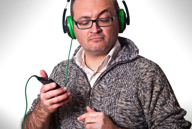 Man att lyssna till musik och att se mobiltelefonen arkivbilder Man att lyssna till musik och att se mobiltelefonen arkivbilder