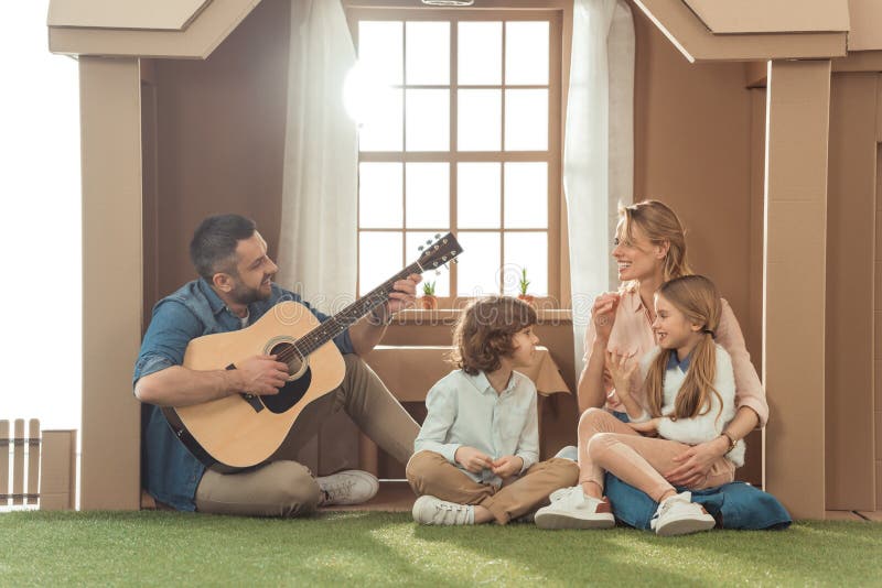 man att spela gitarren för hans familj på nytt arkivfoto man att spela gitarren för hans familj på nytt arkivfoto