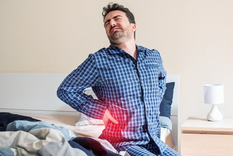 Man with back pain in bed feeling pain stock photography Man with back pain in bed feeling pain stock photography