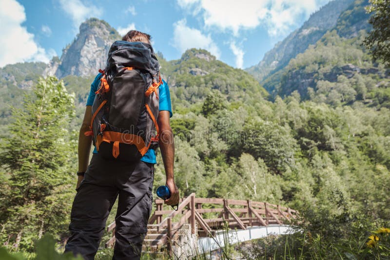 Man with backpack contemplating his next goal surrounded by astonishing nature and mountains royalty free stock images Man with backpack contemplating his next goal surrounded by astonishing nature and mountains royalty free stock images