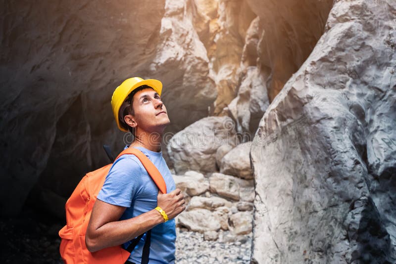 Man with backpack and helmet hiking through a deep and picturesque canyon. Extreme and active recreation royalty free stock photography