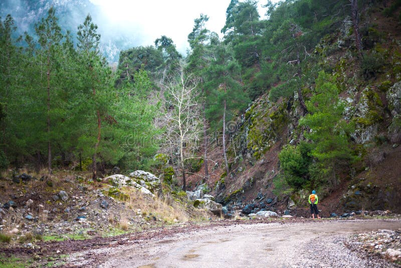 A man with a backpack is on a mountain road royalty free stock image A man with a backpack is on a mountain road royalty free stock image