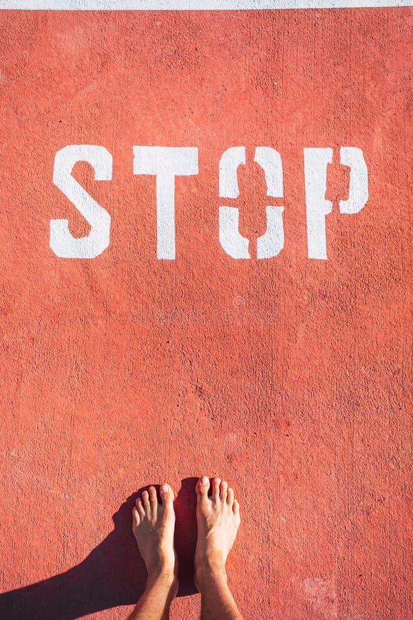 A Man in Bare Feet Stops at a Stop Mark Painted on the Ground Stock
