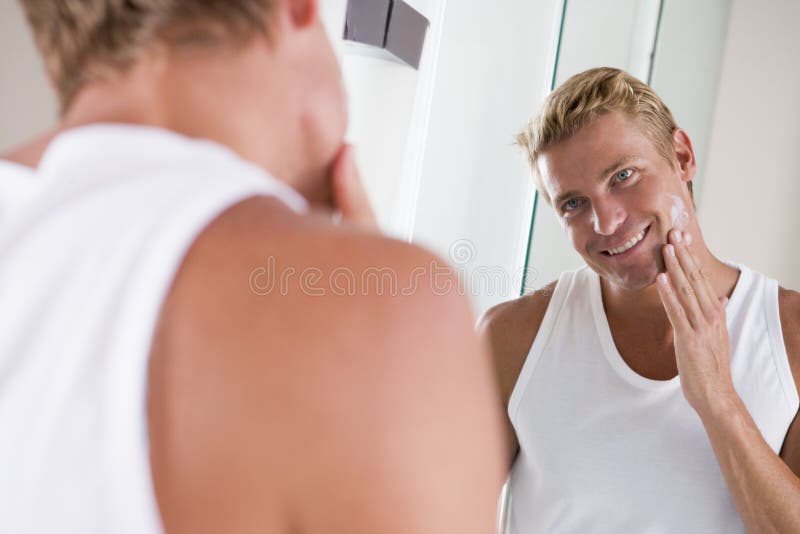 Man in bathroom applying face cream stock photos Man in bathroom applying face cream stock photos