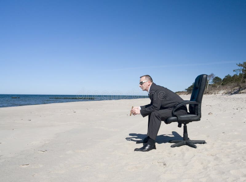 Adult man in business attire and sunglasses, sitting in office swivel chair on white sandy beach in bright sunshine. Adult man in business attire and sunglasses, sitting in office swivel chair on white sandy beach in bright sunshine