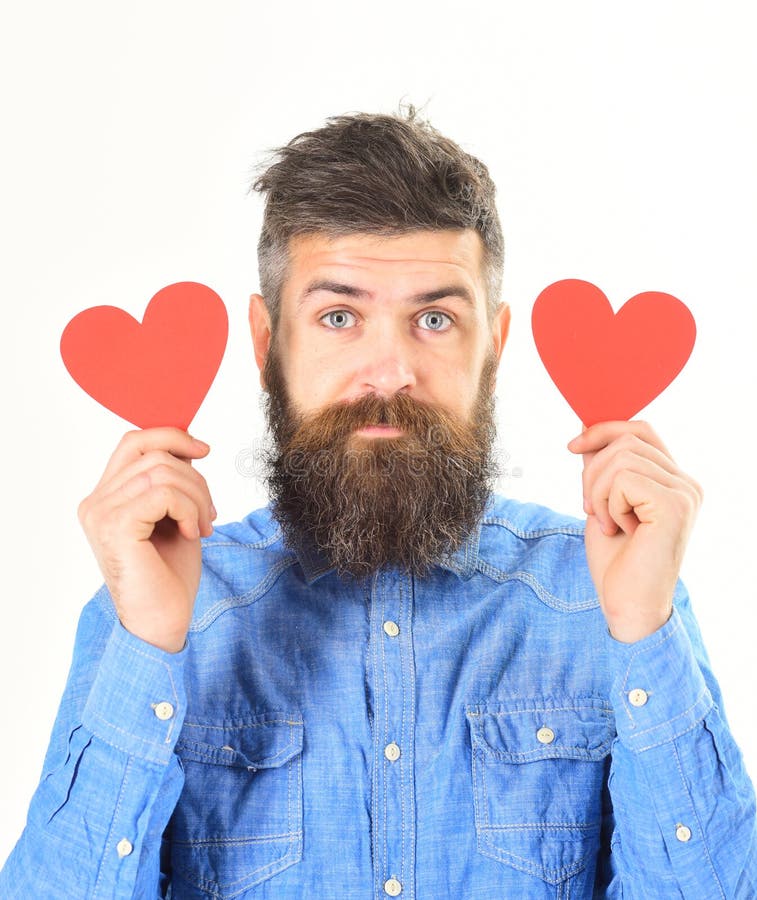 Man with beard with calm face hold red paper hearts stock photos