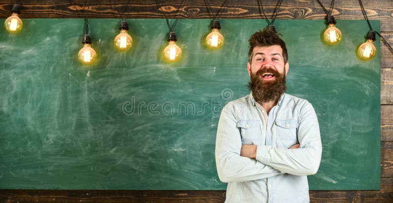 Man with beard and mustache on smiling face stand in front of chalkboard. Best teacher concept. Bearded hipster in shirt royalty free stock images Man with beard and mustache on smiling face stand in front of chalkboard. Best teacher concept. Bearded hipster in shirt royalty free stock images