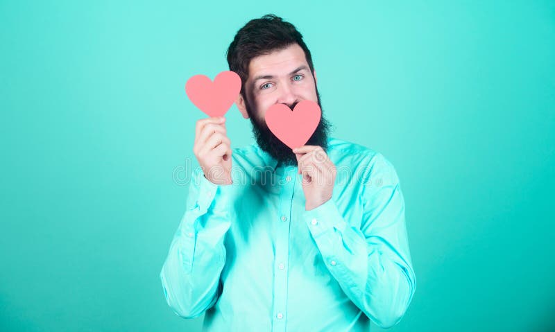 Man bearded hipster with heart valentine card. Celebrate love. Guy attractive beard and mustache in romantic mood royalty free stock photo