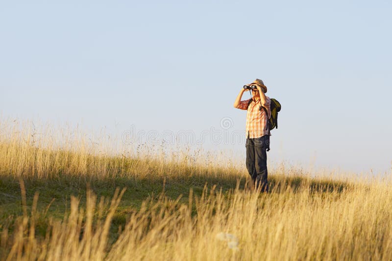 Man binoculars meadow grass