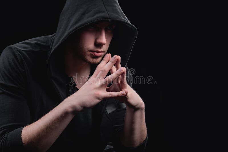 A Man in a Black Hood on a Black Background, Studio Photography. the Idea  of Mysticism, Mystery, Crime and Deception Stock Image - Image of fashion,  concept: 181615931