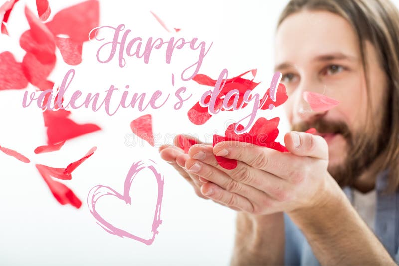 Close-up view of man blowing red paper hearts isolated on white. Close-up view of man blowing red paper hearts isolated on white