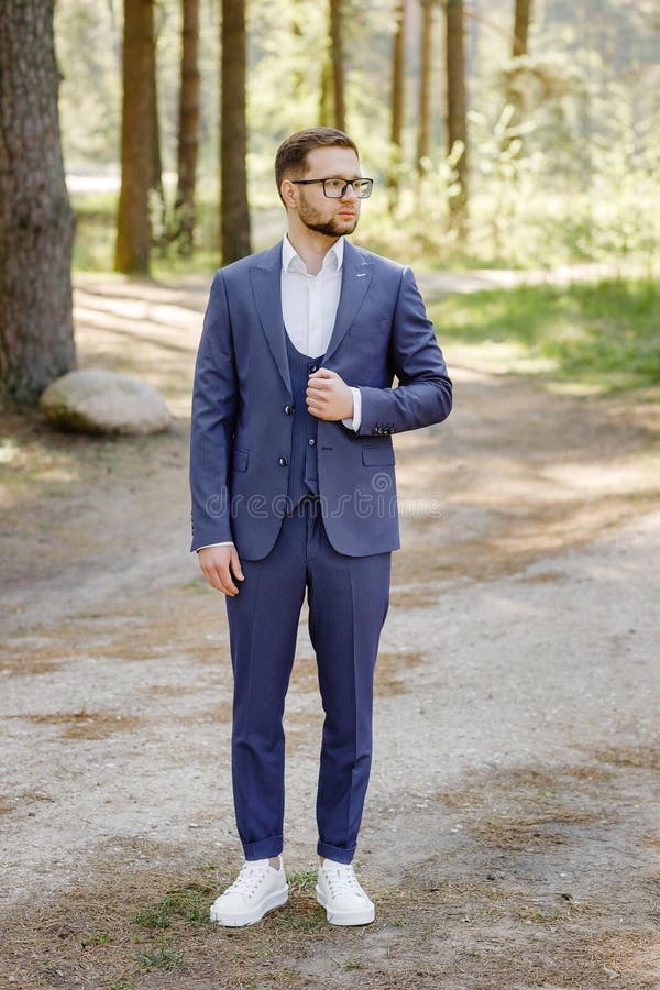 Man in a Blue Suit and White Sneakers Posing in the Forest Stock Photo - Image of handsome,