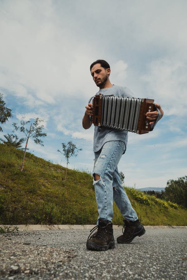 Man With Boots Playing Accordion On The Road royalty free stock image