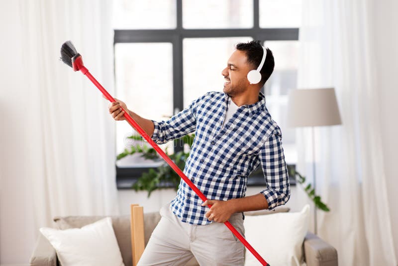 man-broom-cleaning-having-fun-home-housework-housekeeping-concept-indian-headphones-sweeping-153039841.jpg