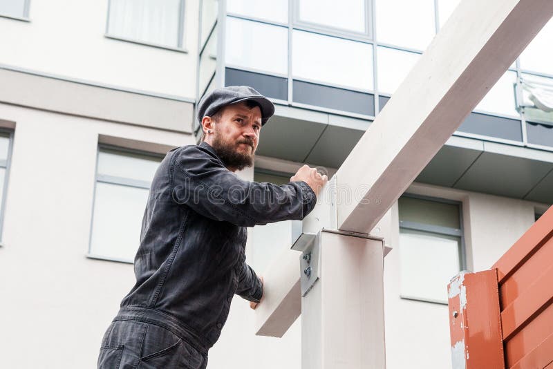 Man builds a house of a wooden beam stock images Man builds a house of a wooden beam stock images