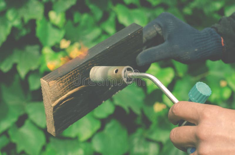 A Man Burns Boards with Fire from a Gas Burner. Stock Photo Image of