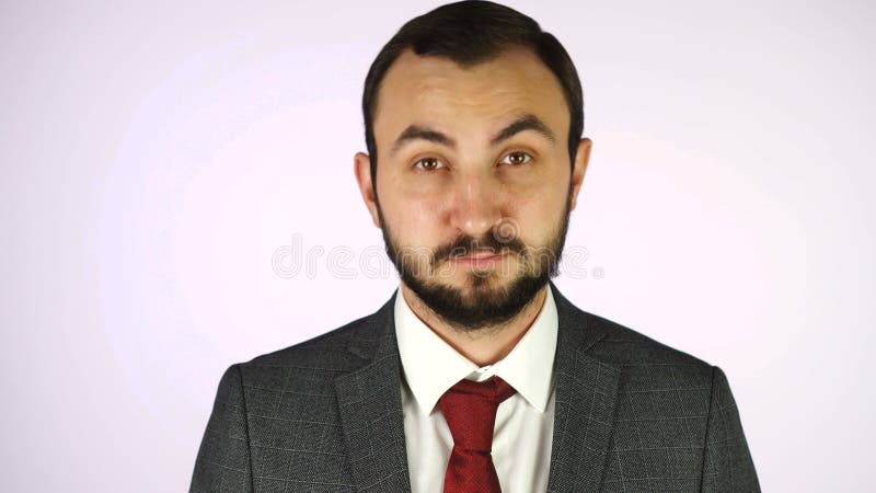 Man in business suit and white shirt adjusts his tie against white background