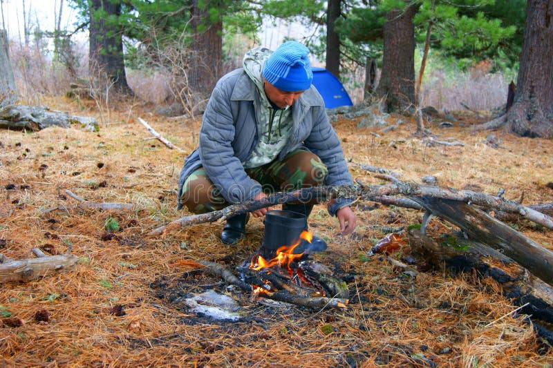 Man beside campfires in wood