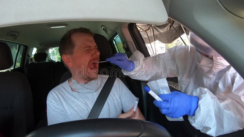 Man in car having oral swab PCR test for possible infection