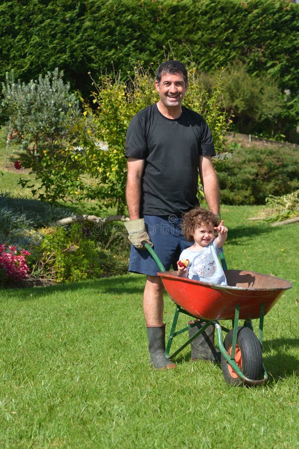 Man carry his daughter in a wheelbarrow royalty free stock photos Man carry his daughter in a wheelbarrow royalty free stock photos