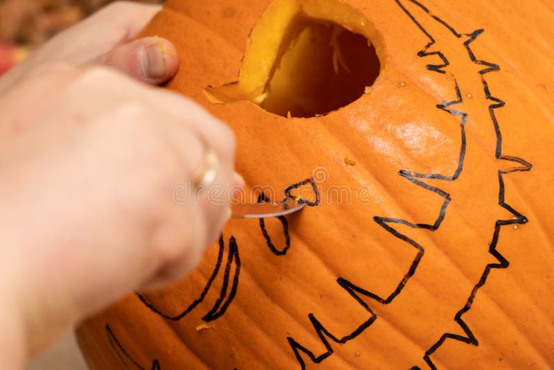 Man carving Halloween pumpkin for decorating holiday of Halloween. Process of making jack-o-lantern stock images