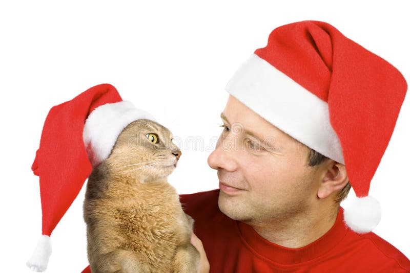 Man and cat in Santa s hat looking at each other