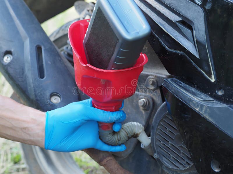 Man Changing the Oil in a Scooter Engine. Stock Image - of equipment, 184339183