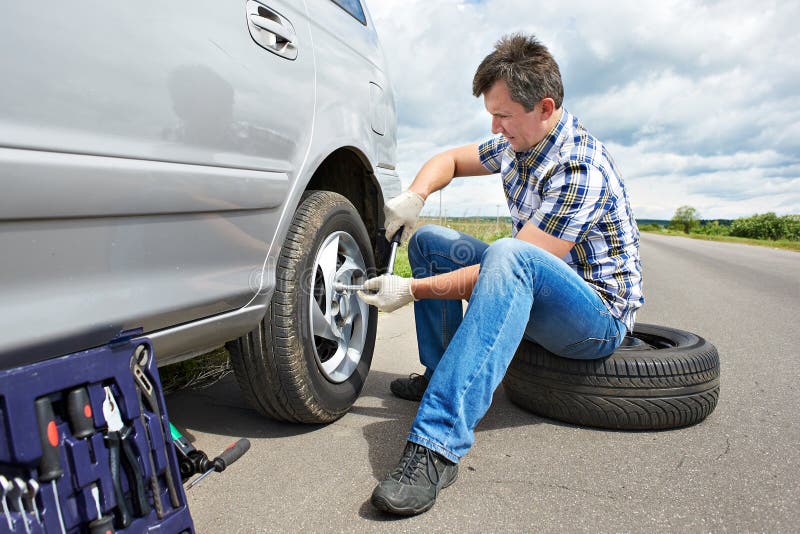 Man Changing Spare Tire of Car Stock Photo - Image of casual, help