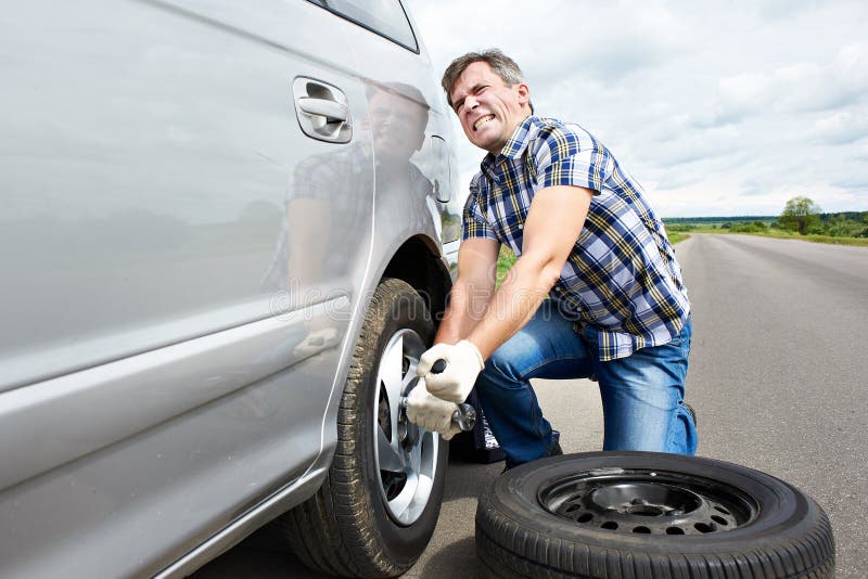 Man Changing a Spare Tire of Car Stock Photo Image of auto, standing
