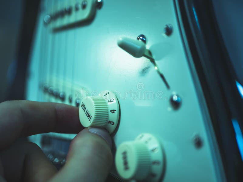 Man changing volume on the electric guitar royalty free stock photography