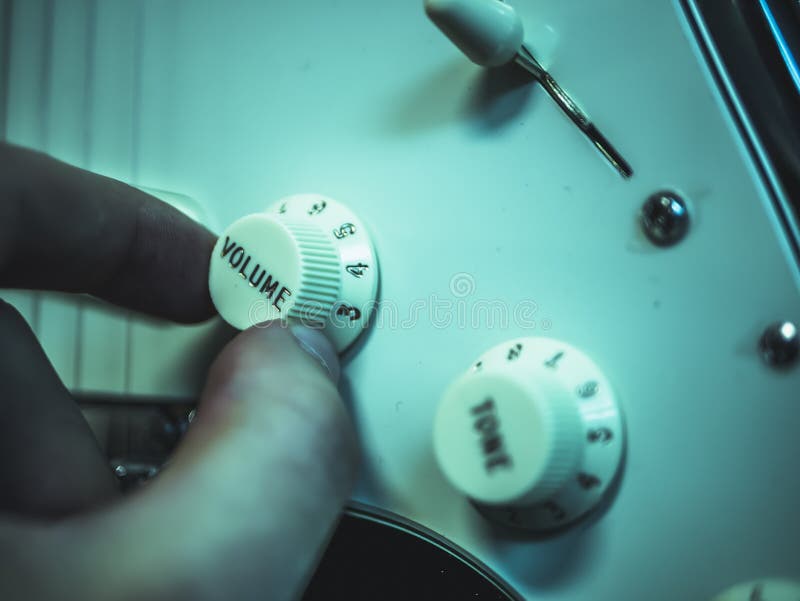 Man changing volume on the electronic guitar royalty free stock photography
